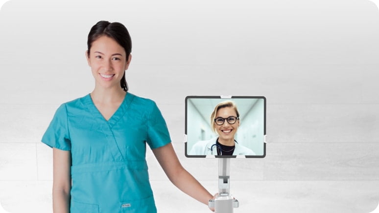 nurse standing next to a medical cart with a doctor in video call